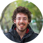 Photo of a close-up shot of George
										  Boumis on a green blurred trees
                                          background. George Boumis has curly
                                          brown hair, wears rectangular
                                          bordeless glasses. Sports a mustache
										  and beard. Wears a black jacket.